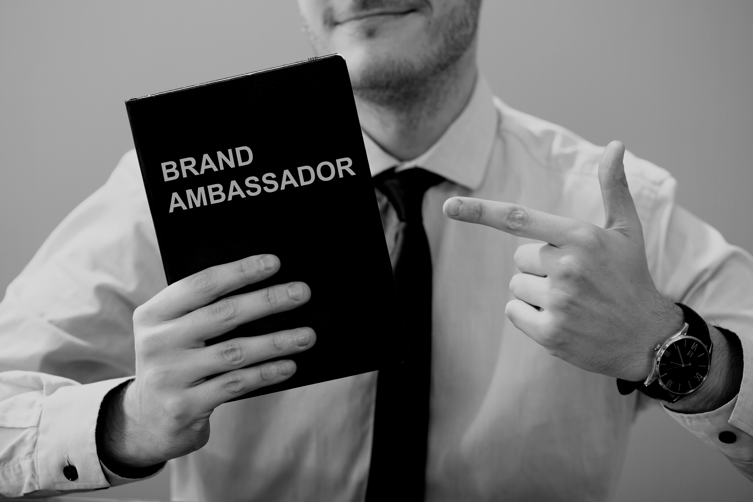 Man Holding Book With Brand Ambassador Text